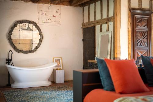 La salle de bains est pourvue d'une baignoire et d'un miroir mural. dans l'établissement Domaine Médiéval à Bergerac, à Montagnac-la-Crempse