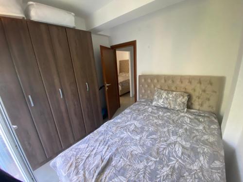 a bedroom with a bed and wooden cabinets at Apartment with three Rooms in Prijevor