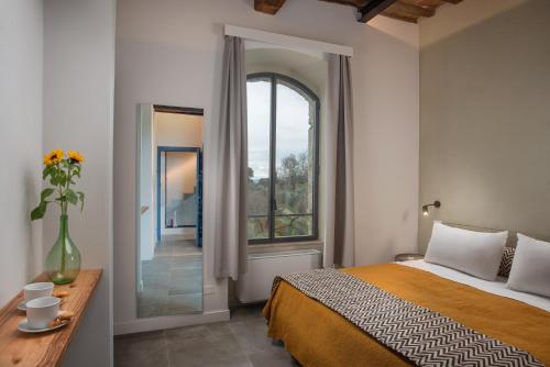 a bedroom with a bed and a large window at Dimora storica Torre dei Petricci 12 in Sovicille