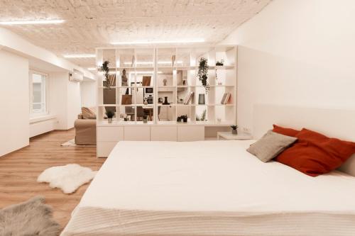 ブダペストにあるHeart of Budapest Apartmentの白いベッドルーム(大型ベッド1台、ソファ付)