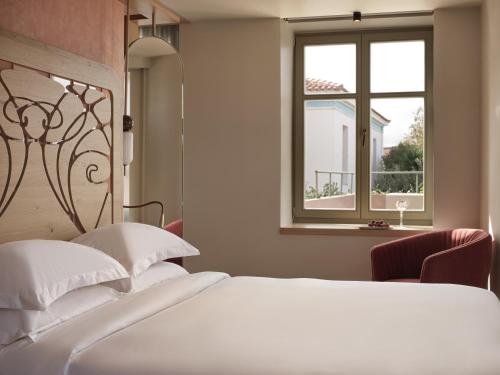 um quarto com uma cama branca e uma janela em Domus Blanc Boutique Hotel em Chania Town