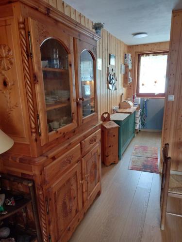 una cocina con un gran armario de madera y un fregadero en Les Airelles 33, Le coin, Molines en Queyras Classé 3 étoiles en Molines-en-Queyras