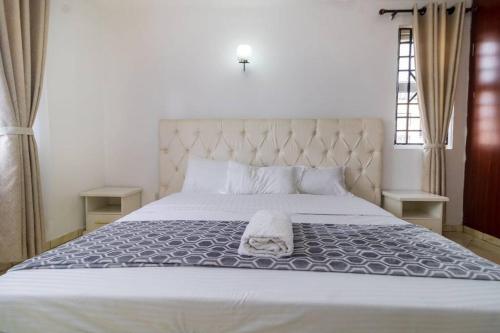 sypialnia z łóżkiem z ręcznikiem w obiekcie Azure Skyline Villa, 3BR Modern Condo Nakuru City. w mieście Nakuru