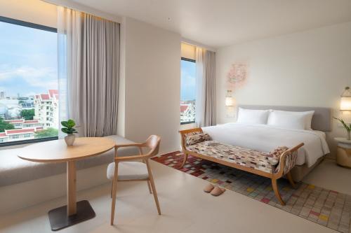 a hotel room with a bed and a table and a window at Centara Ayutthaya in Phra Nakhon Si Ayutthaya
