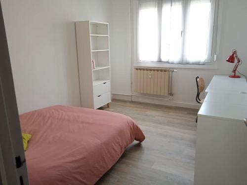 une chambre avec un lit, un bureau et une fenêtre dans l'établissement Appartement tout équipé proche General Electric, à Belfort