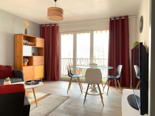 un salon avec une table et des chaises dans l'établissement Appartement tout équipé proche General Electric, à Belfort