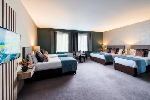 a hotel room with two beds and a flat screen tv at Castlerosse Park Resort in Killarney