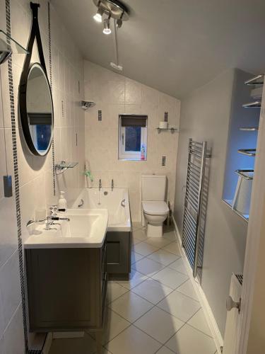 a bathroom with a sink and a tub and a toilet at Norwood Cottage in Kirkby Lonsdale