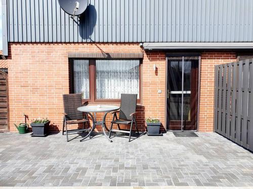 a patio with a table and chairs in front of a brick building at Ruhiges 1-Zimmer-Appartement, Büsum (4km), Nordsee in Oesterdeichstrich