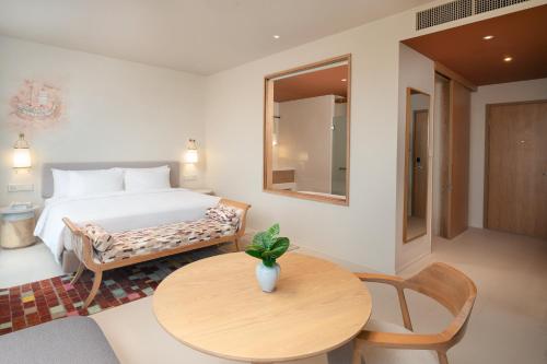 a bedroom with a bed and a table in a room at Centara Ayutthaya in Phra Nakhon Si Ayutthaya
