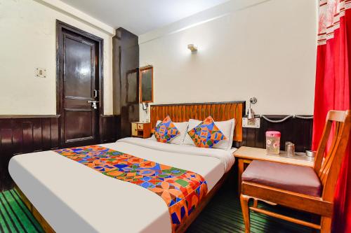 a hotel room with two beds and a chair at FabHotel Park View I in Manāli