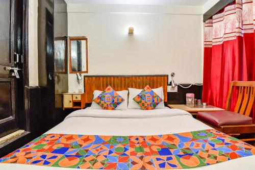 a bedroom with a large bed with a colorful comforter at FabHotel Park View I in Manāli