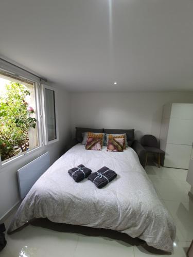 ein Schlafzimmer mit einem Bett mit zwei Handtüchern darauf in der Unterkunft Studio aux portes de Paris in Villejuif