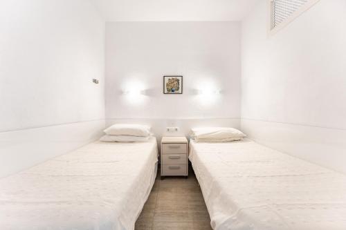 フエンヒロラにあるMarina view, sunny one bedroom pyrの白い壁の部屋にベッドが2つある