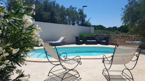 two chairs and a swimming pool in a yard at Une villa en Provence, piscine et jardin ombragé in Velaux