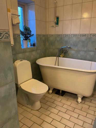 a bathroom with a white tub and a toilet at Villa i Bunkeflostrand in Bunkeflostrand