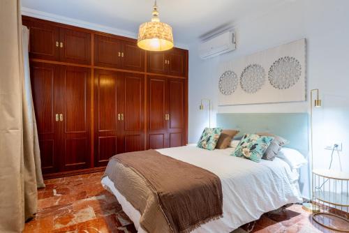 a bedroom with a bed and wooden cabinets at Veoapartment Pastor y Landero in Seville