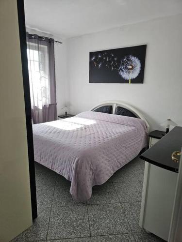 a bedroom with a bed with a purple comforter at La Casa della Lavanda in Borgo Adorno