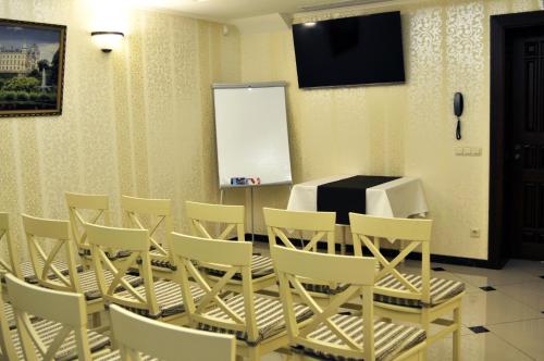 a conference room with a table and chairs and a screen at Status Hotel in Lviv