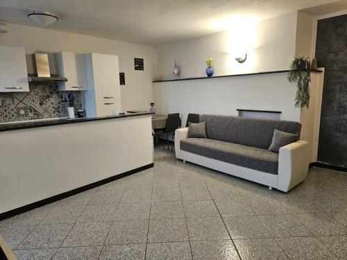 a living room with a couch and a counter at La Casa della Lavanda in Borgo Adorno