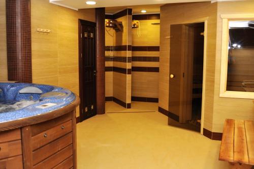 a bathroom with a blue sink and a shower at Status Hotel in Lviv