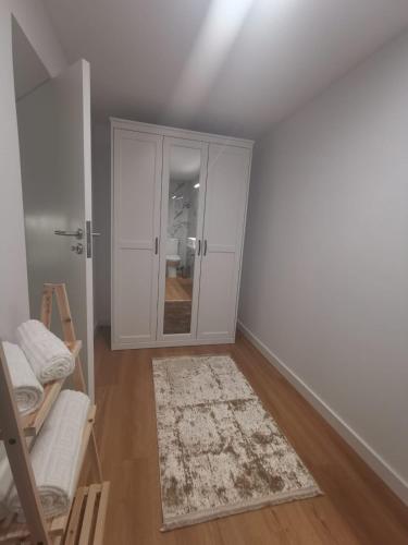 a white room with a closet and a rug at Casa de Pinheiral in Baião