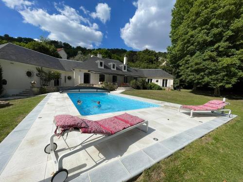 ein Haus mit einem Pool und zwei Liegestühlen in der Unterkunft La Villa Martinière in Bièvres
