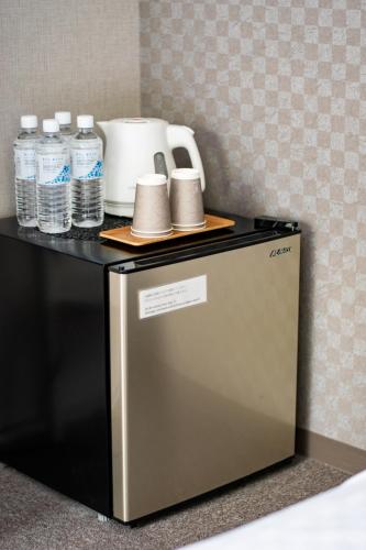 a counter with bottles of water on top of a refrigerator at Hotel Neiraku in Nara