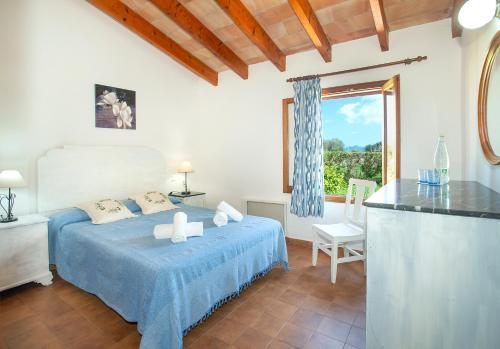 um quarto com uma cama azul e uma janela em Owl Booking Villa Teo - Rustic Stay em Port de Pollensa