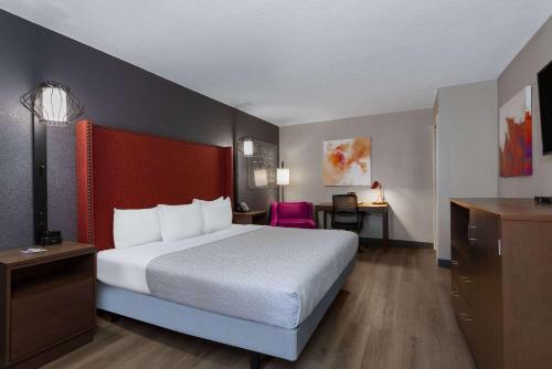 a hotel room with a bed and a desk at La Quinta Inn by Wyndham Pensacola in Pensacola