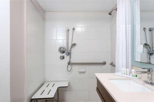 biała łazienka z ławką obok umywalki w obiekcie La Quinta Inn by Wyndham Pensacola w mieście Pensacola