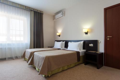 um quarto de hotel com duas camas e uma janela em Kaluga Plaza em Kaluga