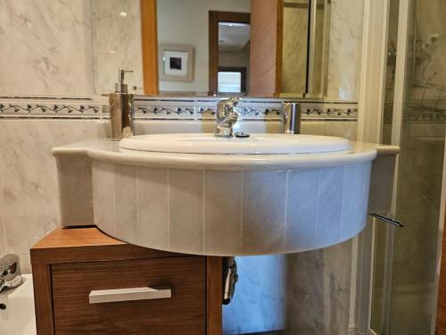 y baño con lavabo blanco y espejo. en 640A Apartamento Laura, en Oviedo
