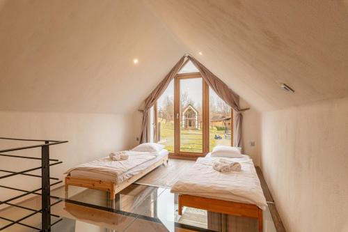 two beds in a room with a large window at GORIČKE IŽE in Križevci