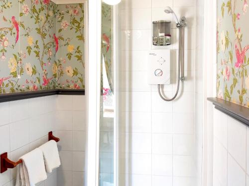 a bathroom with a shower with floral wallpaper at The Mansion House At Kirkhill in Arniston