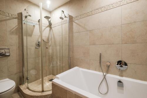 a bathroom with a shower and a tub and a toilet at Ocean Village 2 bedroom apartment in Gibraltar