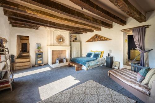 une chambre avec un lit et une cheminée dans l'établissement Domaine Médiéval à Bergerac, à Montagnac-la-Crempse