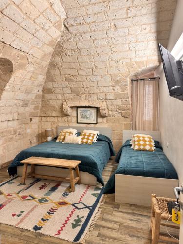 - 2 lits dans une chambre avec un mur en briques dans l'établissement Sister residence rooms, à Bari