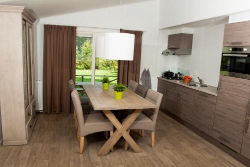 Alphen的住宿－Boslodge XL，厨房配有木桌和椅子