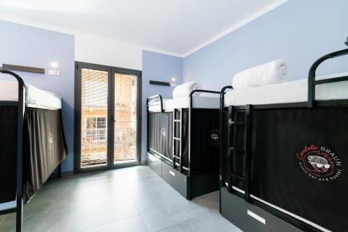 グラナダにあるHostel Carlota Braunの窓付きの部屋の二段ベッドの列