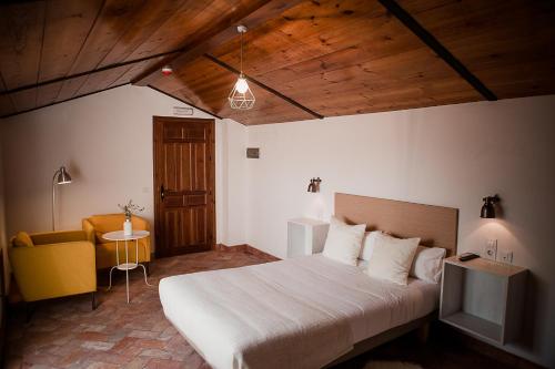 een slaapkamer met een bed, een stoel en een tafel bij Hostal Café FRENTEABASTOS in Carmona