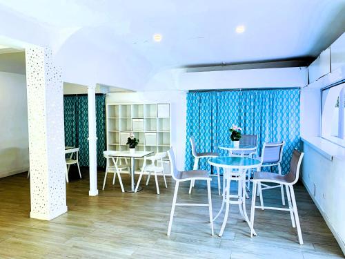 a dining room with tables and chairs and blue curtains at Hotel Fenix in El Arenal
