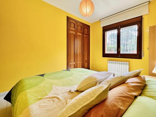 a bedroom with a large bed with yellow walls at Armonia Costabravasi in Santa Cristina d'Aro