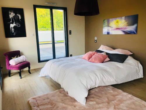 a bedroom with a large bed with pink pillows at Villa piscine 6 personnes in Meyzieu