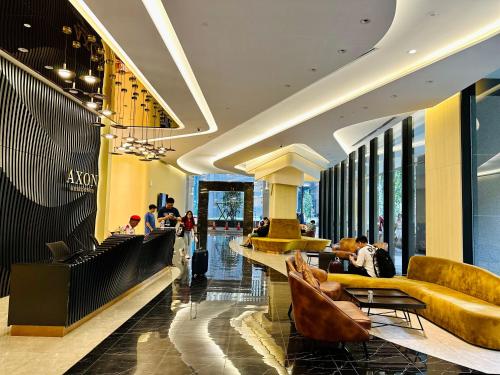 a lobby with couches and chairs in a mall at KL SUITES AT AXON RESIDENCE KLCC in Kuala Lumpur