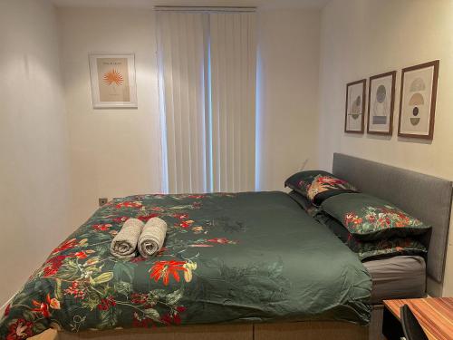 a bed with a green comforter with towels on it at Entire 2BR Flat Rental in Manchester City Centre in Manchester