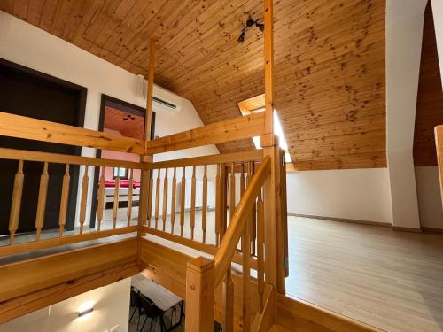 Cette grande chambre est dotée de plafonds en bois et d'un escalier. dans l'établissement Holiday Home Planina, à Tržič