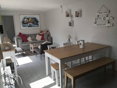 ein Wohnzimmer mit einem Tisch und einem Sofa in der Unterkunft Villa les Maguettes in Le Crotoy