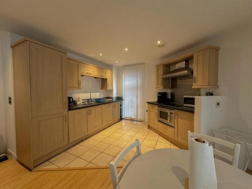 a large kitchen with wooden cabinets and a table and a tableablish at Entire 2BR Flat Rental in Manchester City Centre in Manchester