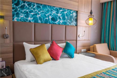 a hotel room with a bed with colorful pillows at Long Beach Alanya - Ultra All Inclusive in Avsallar
